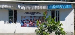 A banner displaying a group of children in traditional clothing in front of a school building.